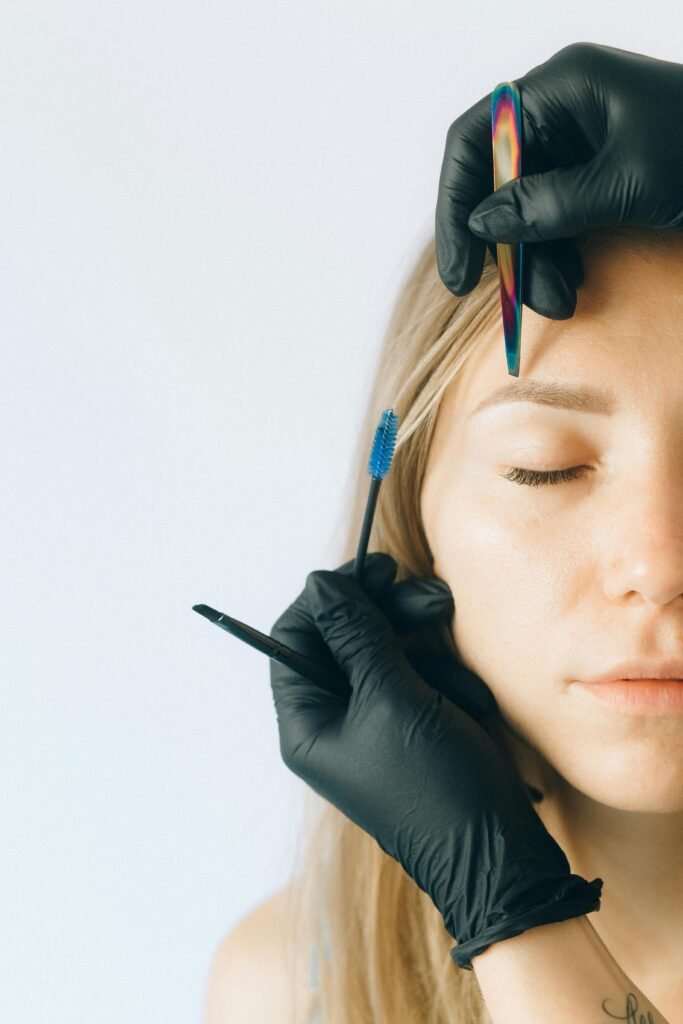 pexels-photo-5128259-5128259 Close-up of a woman receiving professional eyebrow and lash treatment in a beauty salon.
